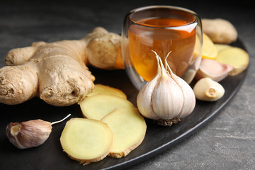 Fresh garlic and other natural cold remedies on grey table