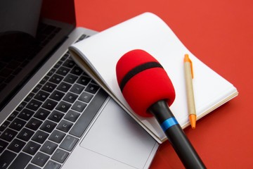 Pen, notebook, microphone and laptop