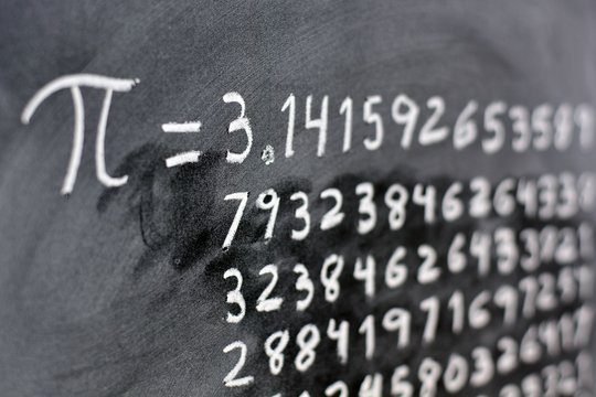 El número pi escrito con tiza en la pizarra, con su equivalencia en números
