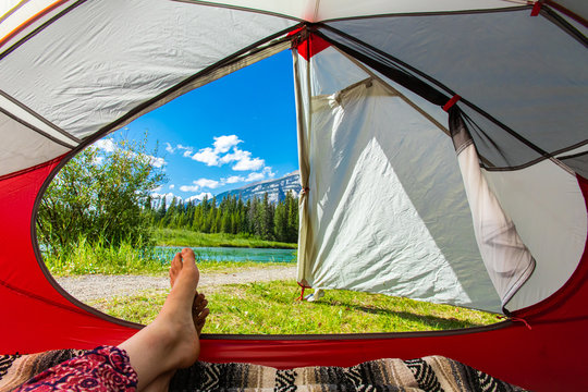 A First Person Perspective From Inside A Camping Tent Of A Lush Green Landscape And The Rocky Mountains In Alberta, Canada, With Copy Space To Right