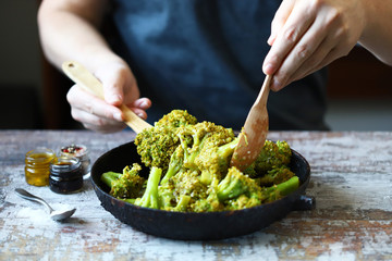 Broccoli cooked in a pan. Chef mixes broccoli. Healthly food.