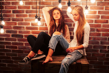 Fototapeta na wymiar two teenage girl friends together having fun in modern loft interior with holiday lights, lifestyle people concept