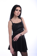 Fototapeta premium Beautiful young brunette woman in black dress on white background
