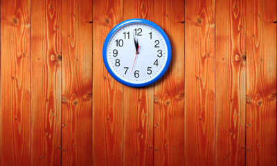 Blue wall clock on a wooden background