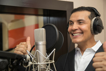 actor and radio announcer with headphones and microphone working film dubbing, performing radio spot and singing