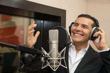 actor and radio announcer with headphones and microphone working film dubbing, performing radio...