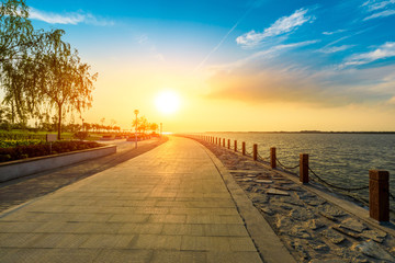 Lakeside road and beautiful sunset sky in the park.