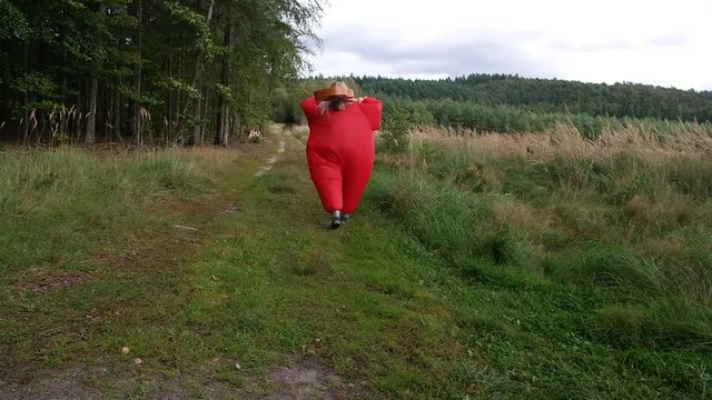 woman in a red outfit plays gitare in the middle of the forest
