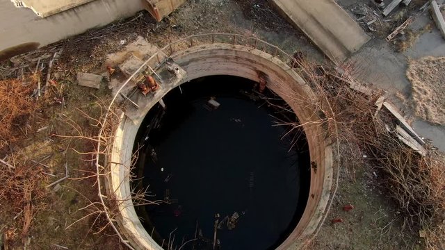 Contaminated water, circular cesspool, environmental waste hazard, rising aerial shot, sewer sewage concept
