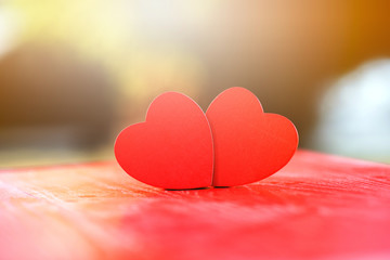 Two wooden hearts On a red wooden table Blurred background, love expression, valentine festival, love concept