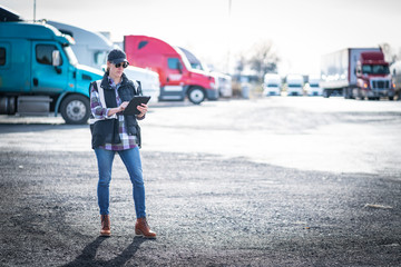 Woman truck driver transportation professional walking in truck yard