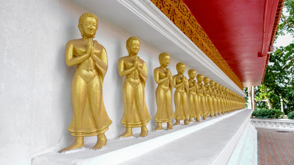 Row of golden Buddhas, perspective view