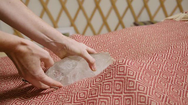 Wide shot of a large clear crystal being placed between the clients feet