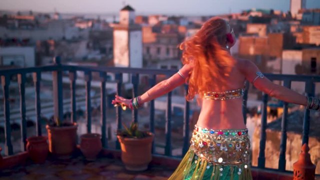 Extreme closeup of beautiful belly dancer performing at sunset on a rooftop in Morocco.