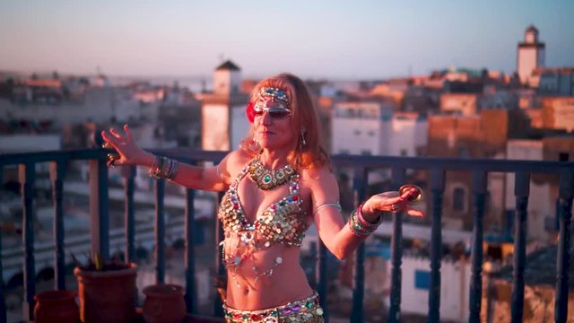 Extreme closeup of beautiful belly dancer doing a head toss at sunset in Morocco.