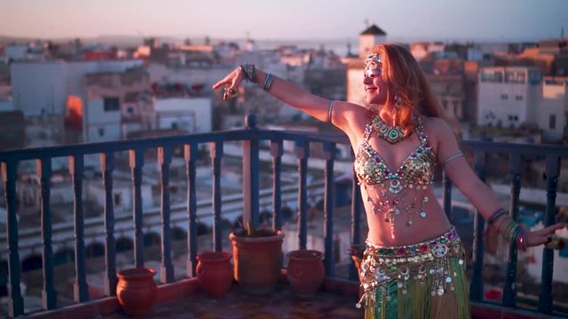 Closeup slow motion backlit belly dancer in Morocco at sunset.