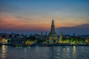 Fototapeta na wymiar Arun pagoda temple waterfront after sunset, The most famous tourist destination of Thailand