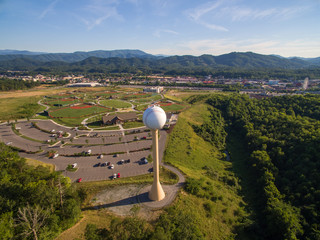 A tourist attraction in Pigeon Forge Tennessee in which a baseball and baseball bat shaped water tower sits in view of the Great Smokey Mountains - obrazy, fototapety, plakaty