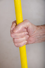 hand with yellow broom