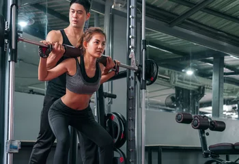 happy personal fitness trainer support his client in a modern gym, fitness gym and sport concept © tuastockphoto