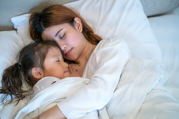 girl sleep in the bed near her mother, happy family concept