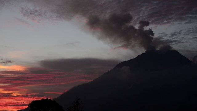 Volcanic smoke billowing out of Mount Sinabung during sunset in Berastagi, Indonesia.