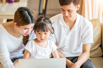 asian family happy people concept - mother and father help their daughter do homework in living room