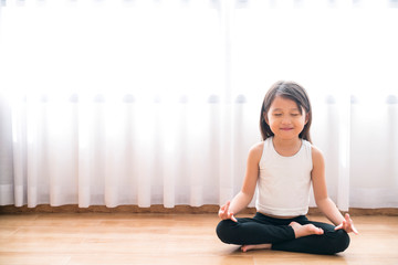asian little cute girl do a yoga at home with space for add text