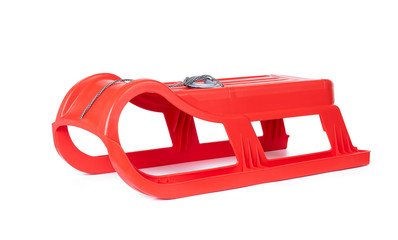Red plastic sled for snow skiing isolated on white background. File contains a path to isolation.