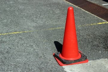 赤い三角コーンと黄色い線の入ったコンクリート
