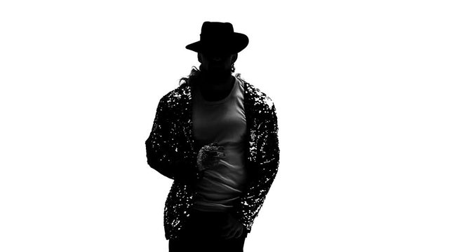 Silhouette of a young man dancer dancing in style Michael Jackson on white background. Close up, slow motion.