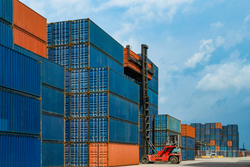 forklift truck lifting cargo container in imports exports logistics area