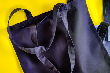 Tote bag made with natural materials on the bright yellow background. Concept of the zero waste lifestyle, environment protection, Earth day.