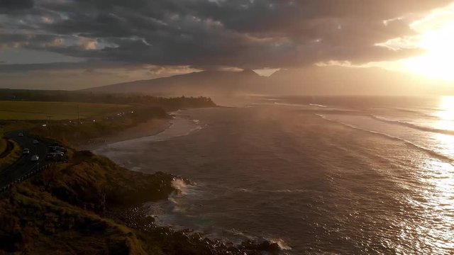 A drone flies over the Maui, Hawaii north shore capturing images near Ho'okipa beach and Paia at sunset.