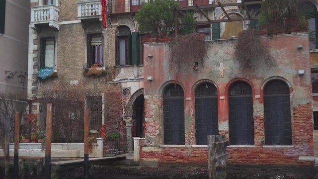 View of an ancient palace beside the canal. Old bricks facade. Venice, Italy. Panoramic view rotating from right to left.