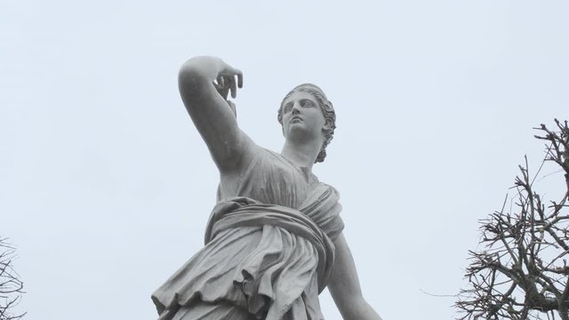 Slow pan of an antique statue in the park