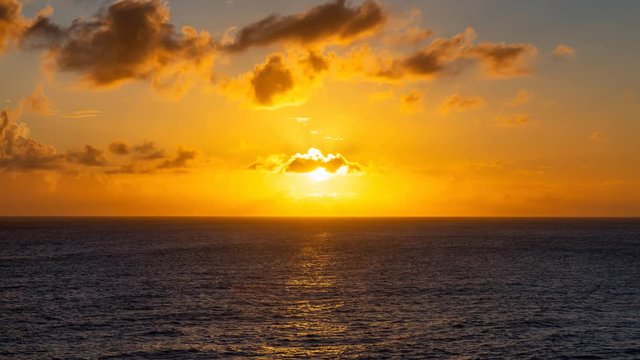 Cinemagraph, Seamless loop Animation. Dramatic View of a cloudscape during a dark and colorful Orange sunset. Taken in the Tropics of Caribbean Sea in Barbados.