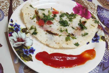 Plate of utthapam garnished with sauce. 