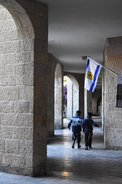 Two Orthodox Jewish children stroll under the banner of the holy city