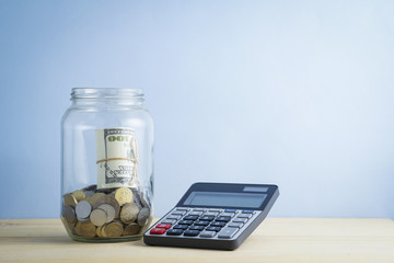 coin into jar with dollar bills and retro clock. saving concept