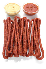 long and thin sausages kabanos with ketchup and mustard on white background, isolated