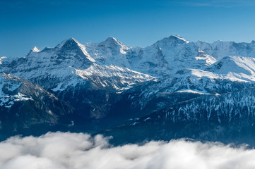 Fototapeta na wymiar Eiger Mönch and Jungfrau in winter above the fog