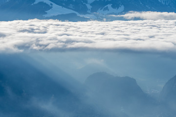 Fototapeta premium layer of clouds with tyndall effect at the flank of Mount Niesen at the entrance of Simmental Valley
