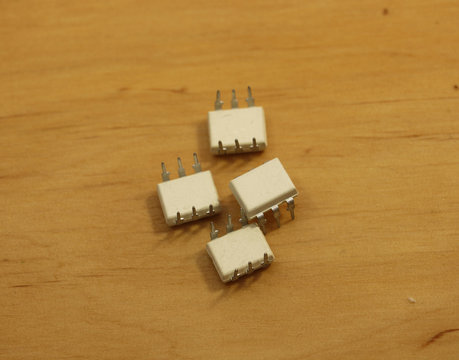 Electronic components. Optocoupler with six pins on wooden background. Microchip.