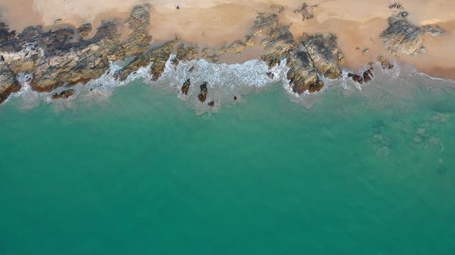 Top Down Drone Footage Of Waves Hitting Rocky Beach