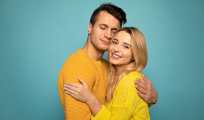 Calm happiness. Close-up photo of a perfect woman and a handsome man with closed eyes, who are hugging and smiling out of joy.