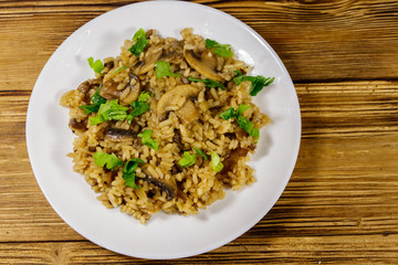 Tasty risotto with mushrooms on wooden table. Top view