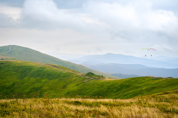 The top of the Carpathian mountains. Beautiful landscape with greenery and people paragliding. Rest and travel..