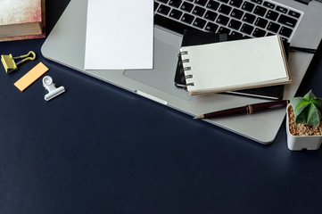 Workspace concept with blank note and pen on laptop.