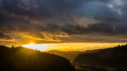 Naklejka na ściany i meble Germany, Magical orange sunset sky over beautiful black forest nature landscape valley with sunrays creating mystical mood